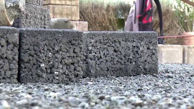 Bauarbeiter verlegt Pflastersteine
(Construction worker laying pavement rocks)