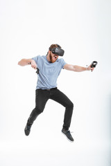 Happy bearded man wearing virtual reality device while jumping