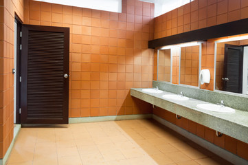 Interior of public clean toilet in a shared toilet there is a wide selection of sinks with mirrors