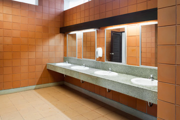 Interior of public clean toilet in a shared toilet there is a wide selection of sinks with mirrors