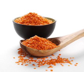 pile red lentils with bowl and wooden spoon isolated on white