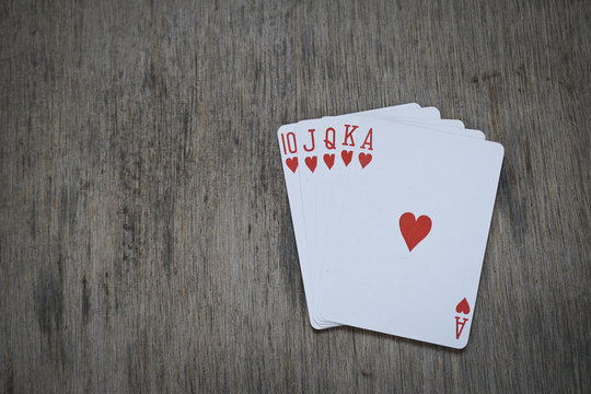 royal flush playing cards isolated on wooden table background