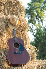 guitar resting on straw Division in the fields, the warm sun of