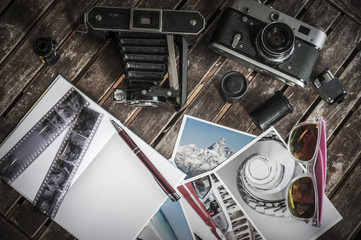 Retro Fotokameras auf einem Tisch / Alte Retro Fotoapparate auf einem Tisch mit Fotografien,...