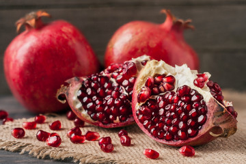 two pomegranate on the old wooden board with sackcloth