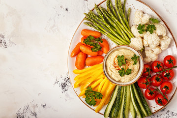 Healthy homemade hummus with assorted fresh vegetables.