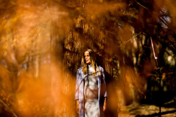 Fototapeta na wymiar Young pregnant woman posing in autumn park