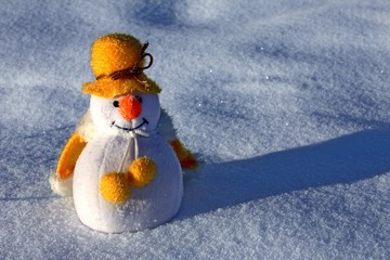 Merry Christmas from cute little toy snowman on snowy sparkle background