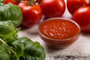 Fresh tomatoes and basil leaves on white background