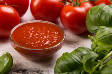 Fresh tomatoes and basil leaves on white background