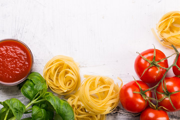 Fototapeta na wymiar Italian food background with vine tomatoes, basil, tagliatelle pasta on white background Top view