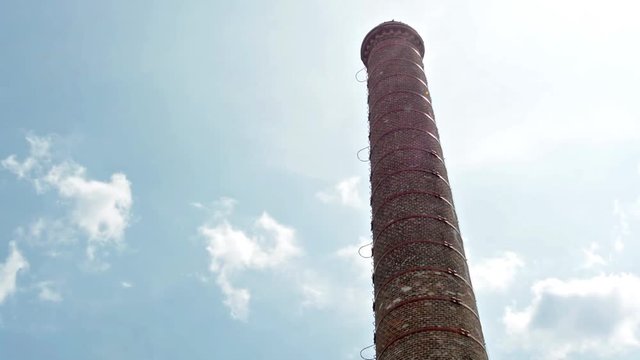 A factory chimney against the blue sky - view from below