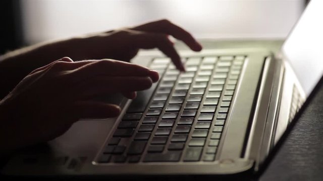 Still shot of a woman's hands working on a laptop.