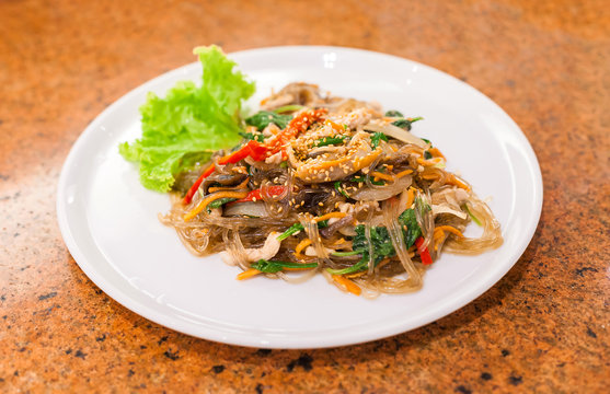 fried vermicelli with mushroom and white sesame on white plate,