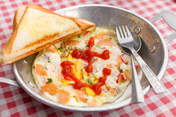 Breakfast fried egg with toppings and garlic bread