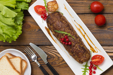 Meatloaf stuffed with mushrooms  sauce and berries. Wooden rustic background. Top view. Close-up
