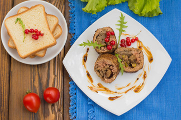 Meatloaf stuffed with mushrooms  sauce and berries. Wooden rustic background. Top view. Close-up