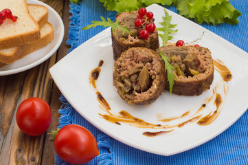 Meatloaf stuffed with mushrooms  sauce and berries. Wooden rustic background. Close-up