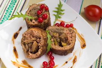 Meatloaf stuffed with mushrooms  sauce and berries. Rustic background. Top view. Close-up