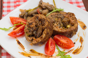 Meatloaf stuffed with mushrooms  sauce and berries. Wooden rustic background. Close-up