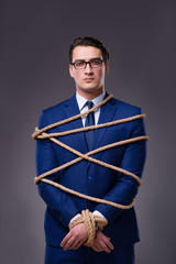 Businessman tied up with rope