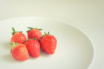 Strawberry on the plate, vintage style effect, selective focus