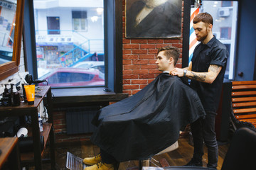 Master cuts hair of men in the barbershop