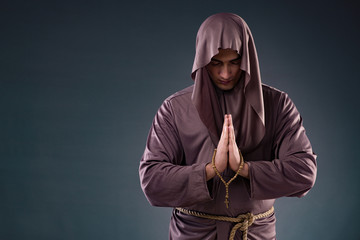 Monk in religious concept on gray background - obrazy, fototapety, plakaty