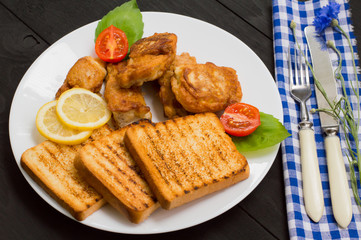 Fish in batter with croutons grilled. Wooden background. Top view. Close-up
