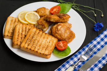 Fish in batter with croutons grilled. Wooden background. Top view. Close-up
