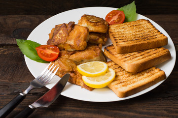 Fish in batter with croutons grilled. Wooden background. Top view. Close-up