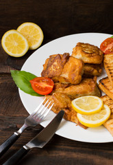 Fish in batter with croutons grilled. Wooden background. Top view. Close-up
