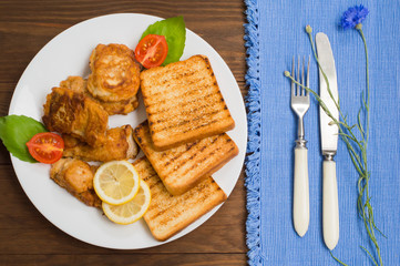 Fish in batter with croutons grilled. Wooden background. Top view. Close-up