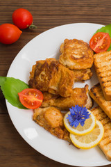 Fish in batter with croutons grilled. Wooden background. Top view. Close-up