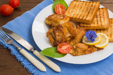 Fish in batter with croutons grilled. Wooden background. Top view. Close-up