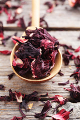 Heap of dry tea with wooden spoon on grey table