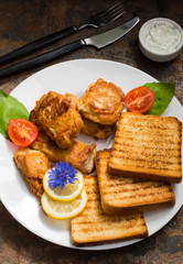 Fish in batter with croutons grilled. Old background. Close-up