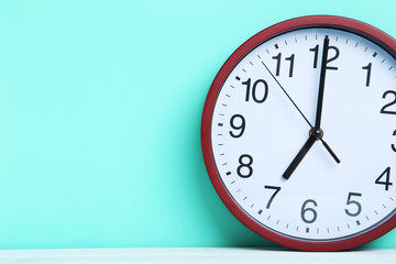 Fototapeta na wymiar Red round clock on a mint background