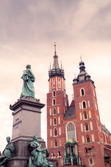 Fototapeta premium Church of St. Mary in the main Market Square on the background of dramatic sky. Basilica Mariacka. Krakow. Poland.