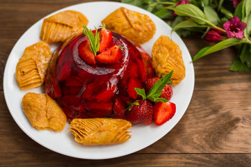 Jelly with strawberries. On a wooden rustic background. Close-up