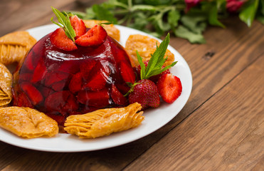 Jelly with strawberries. On a wooden rustic background. Close-up