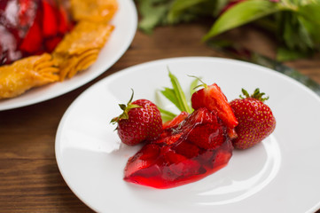 Jelly with strawberries. On a wooden rustic background. Close-up