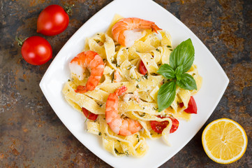 Fettuccine pasta in cream sauce with king prawns on a plate  the wooden table. Top view