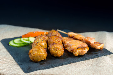 tasty grilled meat and vegetables skewers on a slate plate