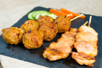 tasty grilled meat and vegetables skewers on a slate plate