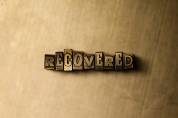 RECOVERED - close-up of grungy vintage typeset word on metal backdrop. Royalty free stock - 3D rendered stock image.  Can be used for online banner ads and direct mail.