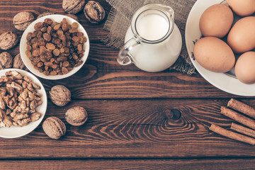 Baking ingredients for homemade pastry on dark rustic wooden background