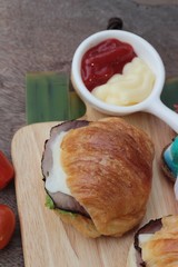Croissant sandwich with grill pork, vegetable and cheese.