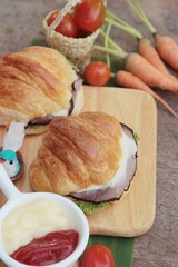 Croissant sandwich with grill pork, vegetable and cheese.