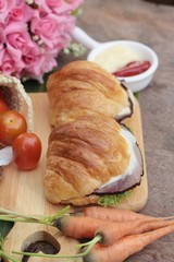 Croissant sandwich with grill pork, vegetable and cheese.